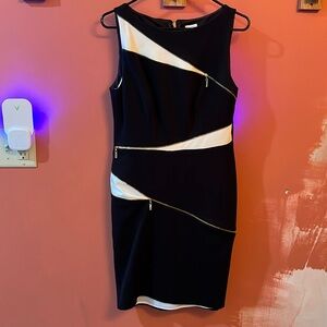 Cache dress black with white peek a boo under gold diagonal zippers.